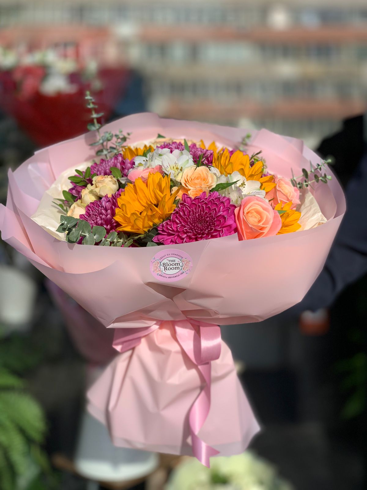 Buchet vibrant și vesel cu floarea soarelui, trandafiri, crizanteme și alstroemeria. Perfect pentru a aduce bucurie și energie pozitivă.