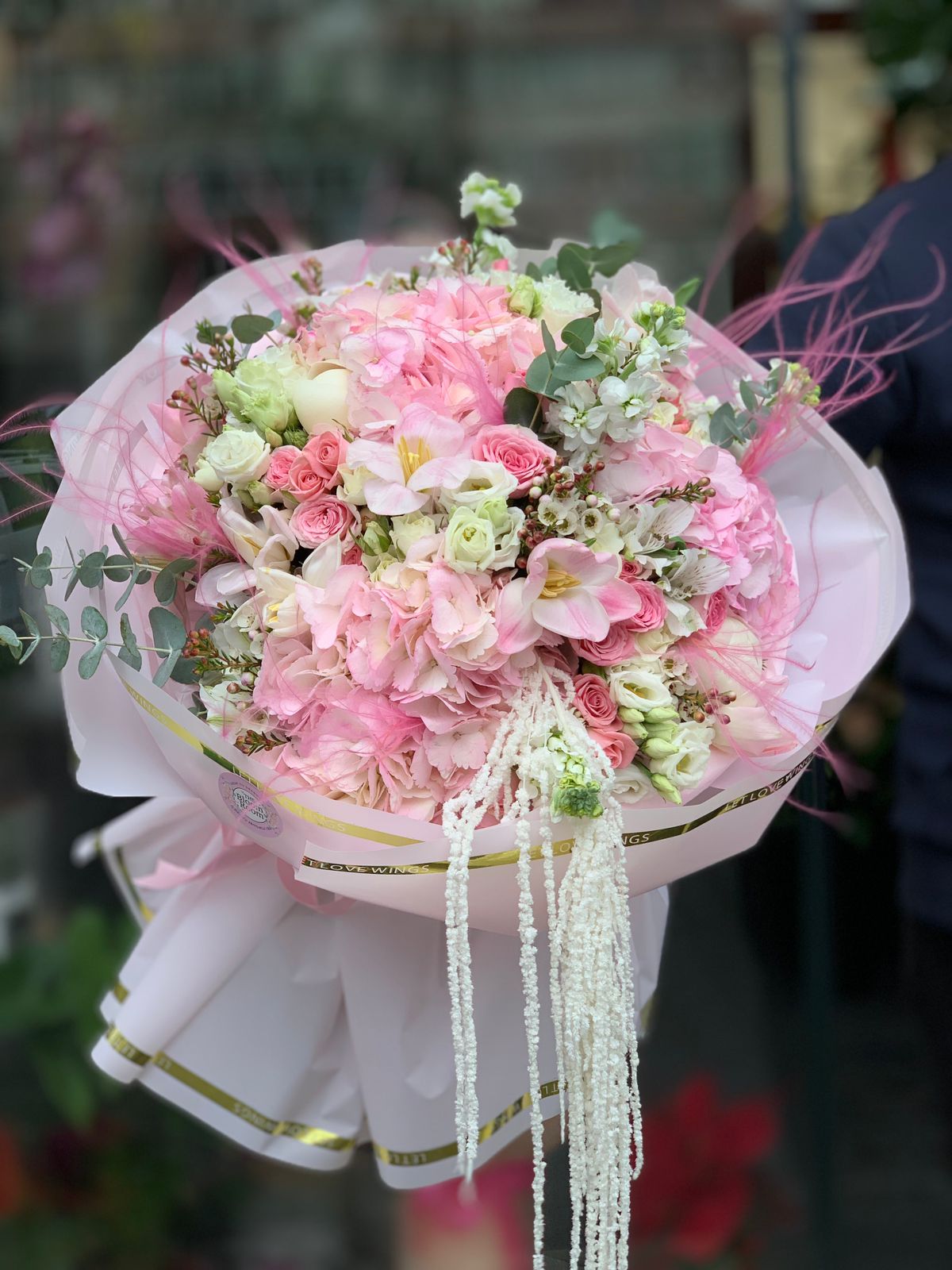 Premium Buchet  cu trandafiri albi, trandafiri roz piersică și lisianthus alb ambalat în hârtie albă, livrare The Bloom Room București